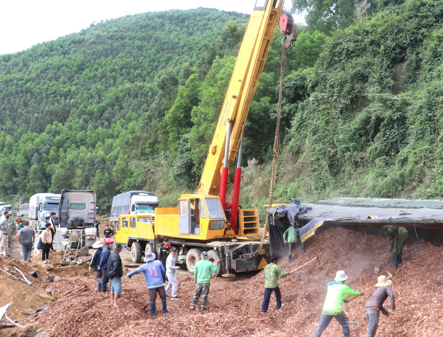 Xe container chở vụn gỗ, lật nghiêng chiếm ½ mặt đường, gây tắc nghẽn giao thông. Ảnh: Ngọc Minh