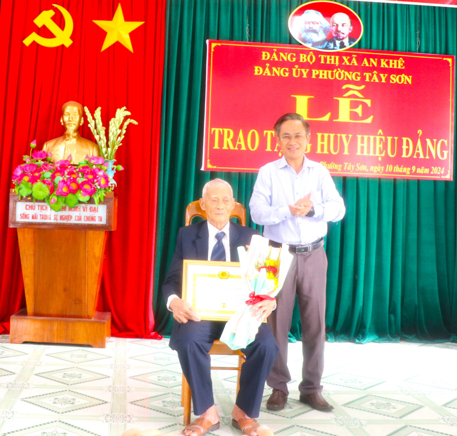 Đồng chí Nguyễn Xuân Phước-Tỉnh ủy viên, Bí thư Thị ủy An Khê trao tặng Huy hiệu 70 năm tuổi Đảng cho đảng viên Lê Đình Quảng. Ảnh: Ngọc Minh Đồng chí Nguyễn Xuân Phước-Tỉnh ủy viên, Bí thư Thị ủy An Khê trao tặng Huy hiệu 70 năm tuổi Đảng cho đảng viên Lê Đình Quảng. Ảnh: Ngọc Minh