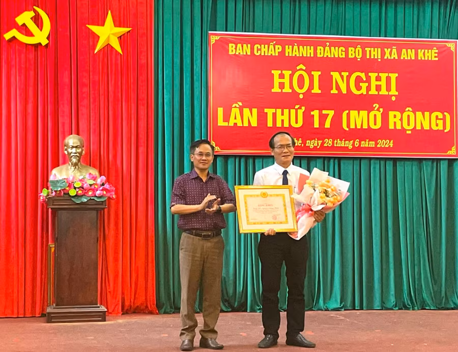 Đồng chí Nguyễn Xuân Phước (bìa trái)-Tỉnh ủy viên, Bí thư Thị ủy An Khê trao bằng khen của Ban Thường vụ Tỉnh uỷ Gia Lai cho cho đồng chí Nguyễn Hoàng Phước-Chi bộ đầu tư nguyên liệu (Đảng bộ Nhà máy đường An Khê, thị xã An Khê). Ảnh: Ngọc Minh