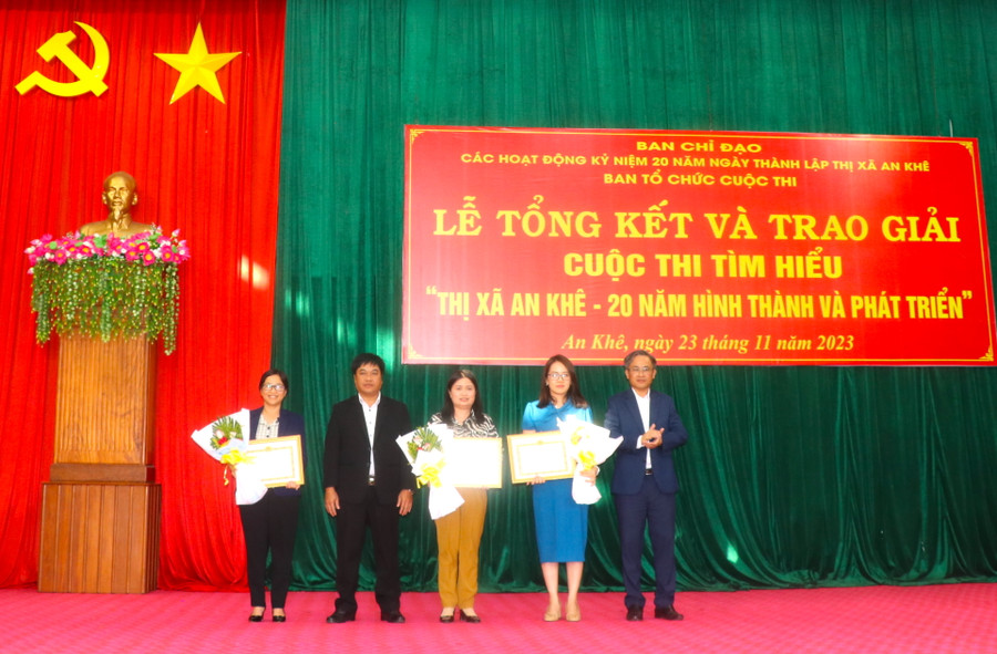 Bí thư Thị ủy An Khê Nguyễn Xuân Phước (bìa phải), Phó Bí thư Thường trực Thị ủy An Khê Đinh Văn Cương (thứ 2 bên trái) trao giấy khen và hoa cho đại diện các tập thể đạt giải Cuộc thi. Ảnh: Ngọc Minh