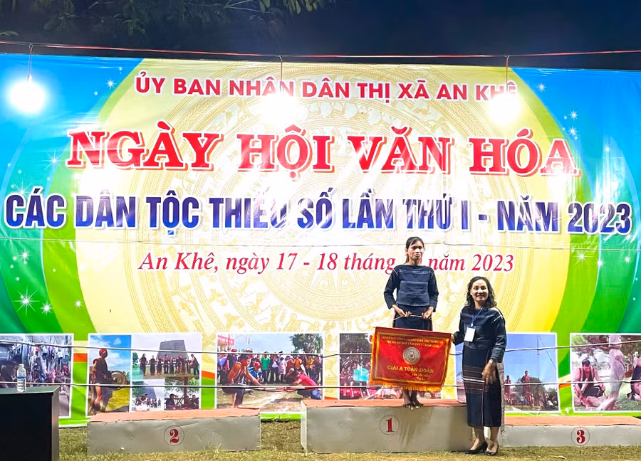 Phó Chủ tịch UBND thị xã An Khê Lê Thị Hồng Minh trao giải nhất toàn đoàn cho đại diện đoàn nghệ nhân làng Hòa Bình (xã Tú An, thị xã An Khê). Ảnh: Ngọc Minh