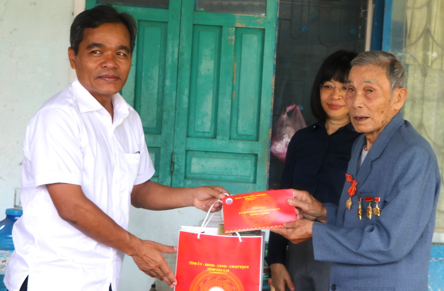 Bí thư Tỉnh ủy Gia Lai Hồ Văn Niên (bìa trái) thăm, tặng quà ông Phạm Lộng (phường An Phú, thị xã An Khê)-thanh niên xung phong tham gia trận đánh Đak Pơ. Ảnh: Ngọc Minh
