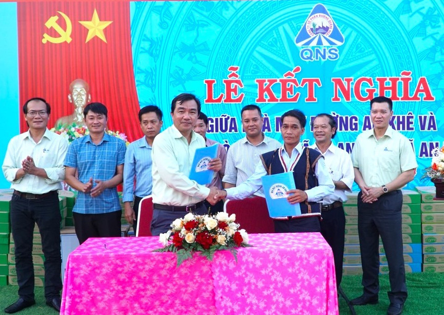 Đại diện Ban Giám đốc Nhà máy Đường An Khê và đại diện làng Hòa Bình ký kết bản giao ước kết nghĩa. Ảnh: Ngọc Đức