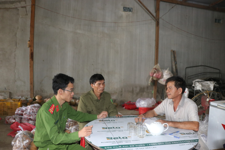 Lực lượng Công an xã, công an viên xã Cư An, huyện Đak Pơ tuyên truyền, nhắc nhở đại lý kinh doanh buôn bán rau cam kết, chấp hành quy định về ATGT. Ảnh: Ngọc Minh