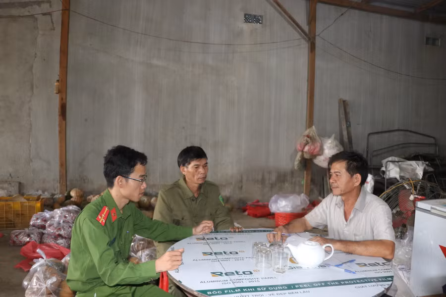 Lực lượng Công an xã, công an viên xã Cư An, huyện Đak Pơ tuyên truyền, nhắc nhở đại lý kinh doanh buôn bán rau cam kết, chấp hành quy định về ATGT. Ảnh: Ngọc Minh