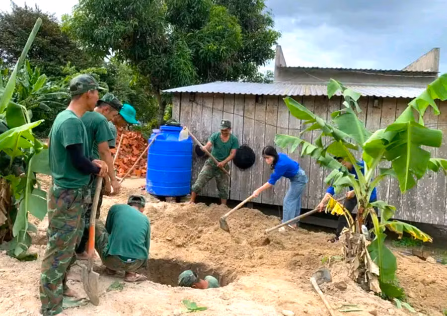Lực lượng quân đội, đoàn viên thanh niên giúp dân làng Đê Chơ Gang (xã Phú An, huyện Đak Pơ) đào hầm rút nước thải. Ảnh: Ngọc Minh