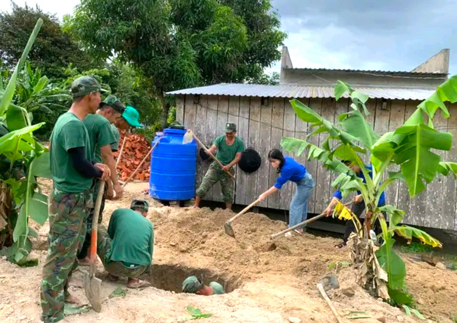 Lực lượng quân đội, đoàn viên thanh niên giúp dân làng Đê Chơ Gang (xã Phú An, huyện Đak Pơ) đào hầm rút nước thải. Ảnh: Ngọc Minh