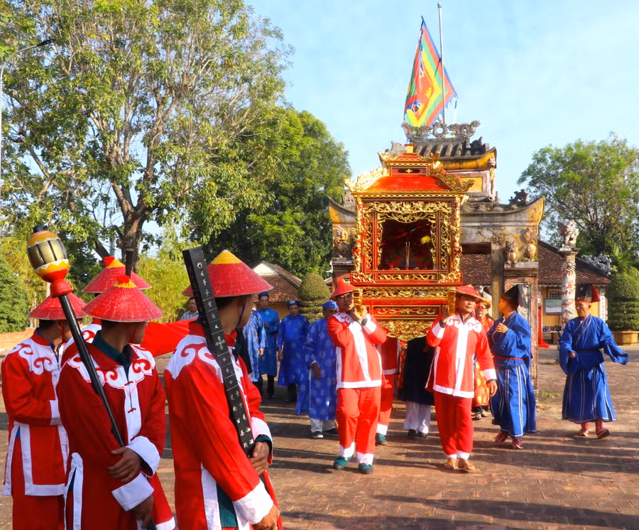 Sắc thần được để bên trong long đình. Ban Nghi lễ đình An Khê cùng các bô lão, đội nghênh long đình, nghinh sắc thần đi qua nhà ngõ trước An Khê trường. Dẫn đầu đoàn nghinh sắc thần là vị trưởng lão cùng đội nghênh long đình, cầm cờ ngũ hành, binh khí trong trang phục binh lính thời xưa, đầu đội nón, oai phong tiến về phía trước. Kế đến là các chức sắc, người dân trong vùng theo sau. Ảnh: Ngọc Minh