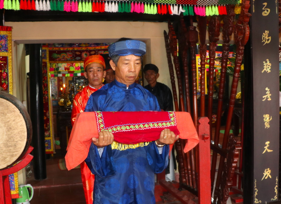 Nhiều năm nay, ông Trần Quang Khánh-Phó Ban Nghi lễ đình An Khê đảm nhiệm trọng trách bảo quản, giữ sắc phong vua ban. Ông Khánh là người duy nhất được phép bưng sắc thần đưa ra long đình và đem sắc thần từ long đình vào cất giữ cẩn thận. Ảnh: Ngọc Minh