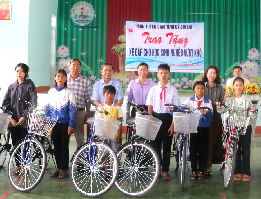 Trưởng Ban Tuyên giáo Tỉnh ủy Gia Lai Huỳnh Thế Mạnh (thứ 4 bên trái) tặng xe đạp cho học sinh nghèo vượt khó học giỏi Trường Tiểu học và THCS Phan Bội Châu (xã Phú An, huyện Đak Pơ). Ảnh: Ngọc Minh