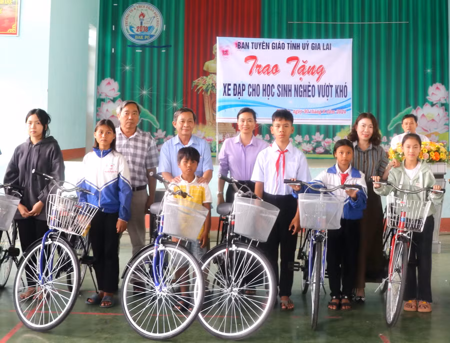 Trưởng Ban Tuyên giáo Tỉnh ủy Gia Lai Huỳnh Thế Mạnh (thứ 4 bên trái) tặng xe đạp cho học sinh nghèo vượt khó học giỏi Trường Tiểu học và THCS Phan Bội Châu (xã Phú An, huyện Đak Pơ). Ảnh: Ngọc Minh
