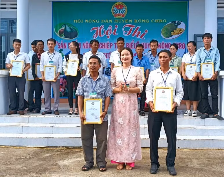 Đại diện Ban tổ chức trao đồng giải nhất cho sản phẩm nhãn T6 của Hội Nông dân xã Yang Trung và sản phẩm mắc ca của Hội Nông dân xã Chư Krey. Ảnh: Ngô Chiến