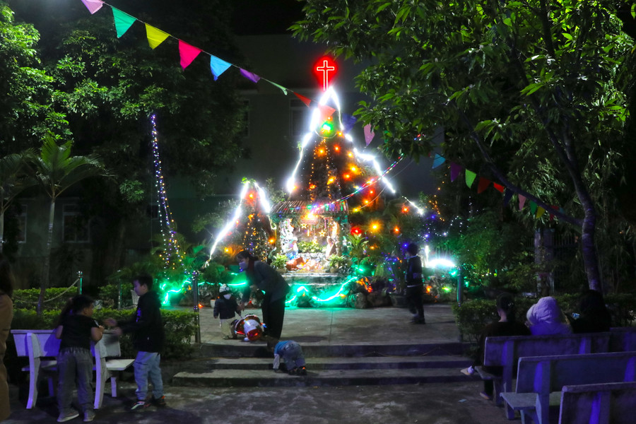 Người dân và trẻ em vui chơi trước hang đá tại Nhà thờ Chợ Đồn (phường An Bình, thị xã An Khê). Ảnh: Ngọc Minh