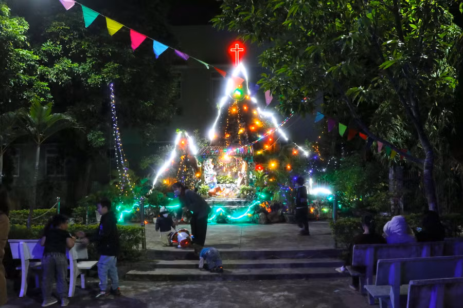 Người dân và trẻ em vui chơi trước hang đá tại Nhà thờ Chợ Đồn (phường An Bình, thị xã An Khê). Ảnh: Ngọc Minh