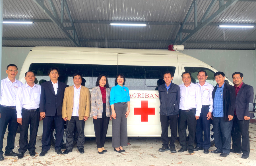 Các đại biểu chụp hình bên xe cứu thương do Agribank chi nhánh thị xã An Khê Đông Gia Lai tài trợ cho Trung tâm Y tế thị xã An Khê. Ảnh: Ngọc Minh