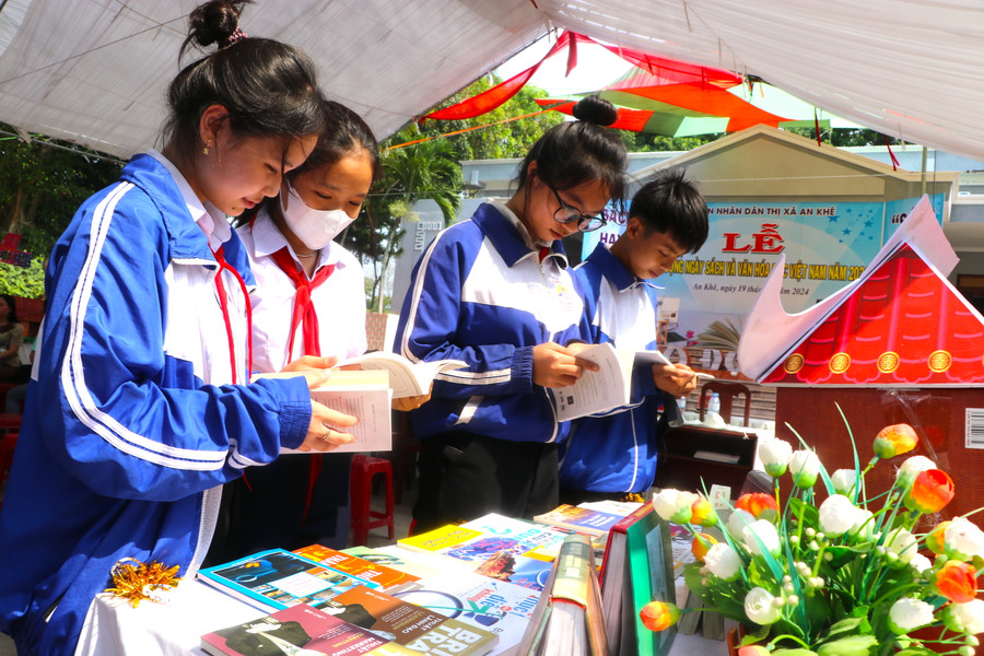 Một số học sinh Trường THCS Đề Thám tham quan mô hình xếp sách nghệ thuật và tìm đọc những cuốn sách hay. Ảnh: Ngọc Minh