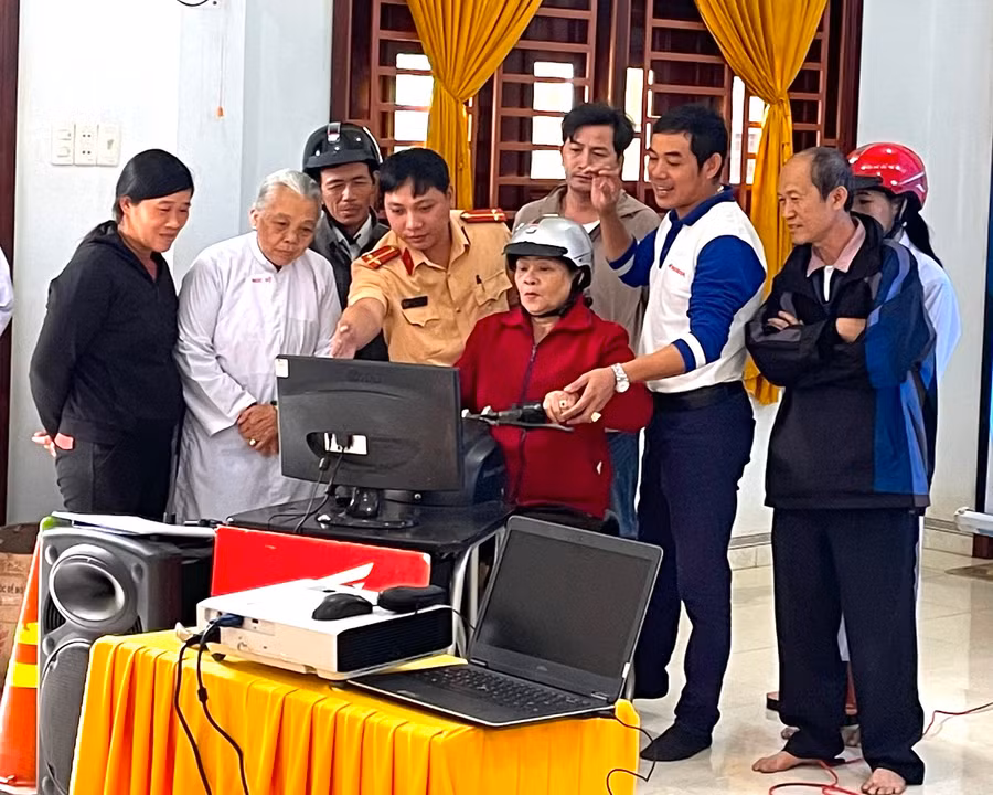 Cảnh sát giao thông (Công an thị xã An Khê) hướng dẫn phật tử lái xe an toàn và đội mũ bảo hiểm đúng quy cách khi đi mô tô, xe gắn máy. Ảnh: Ngọc Minh