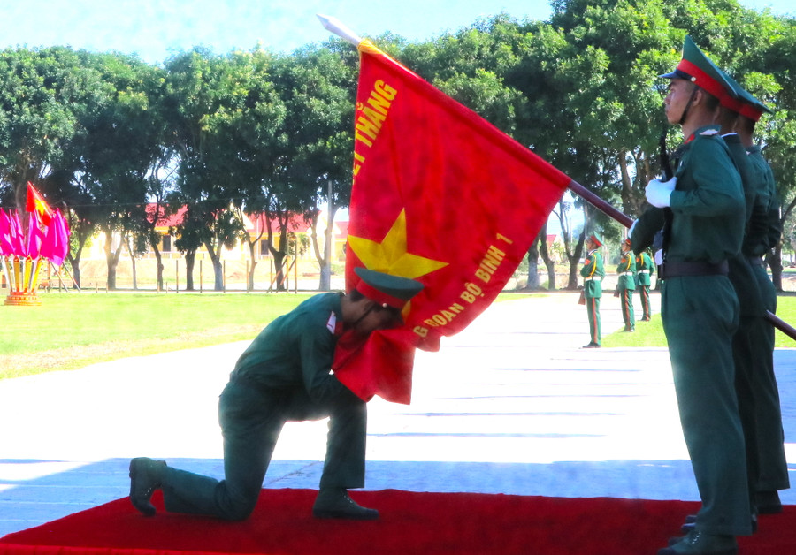 Chiến sĩ mới thực hiện nghi thức hôn lên Quân kỳ Quyết thắng tại lễ tuyên thệ. Ảnh Ngọc Minh