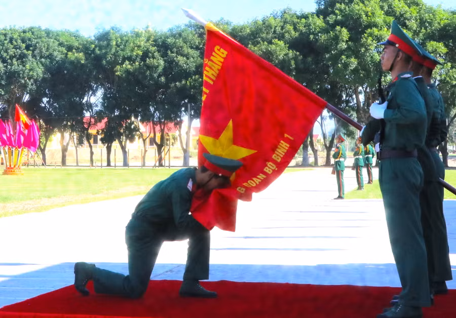 Chiến sĩ mới thực hiện nghi thức hôn lên Quân kỳ Quyết thắng tại lễ tuyên thệ. Ảnh Ngọc Minh