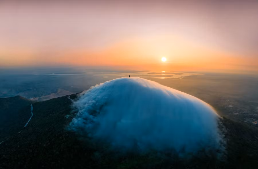 Mây thấu kính với hình dạng tựa chiếc nón mây trắng bồng bềnh úp trên đỉnh núi là một hiện tượng mây hiếm gặp trên thế giới, nhưng là "đặc sản" khá dễ gặp tại núi Bà, đặc biệt trong thời điểm từ tháng 4 này. Ảnh: NGUYỄN MINH TÚ