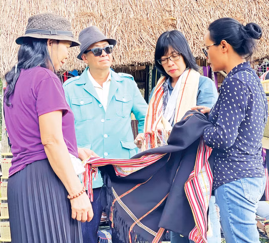 Phó Chủ tịch UBND tỉnh Nguyễn Thị Thanh Lịch (thứ 2 từ phải sang) khen ngợi hoa văn độc đáo, mới lạ trên tấm thổ cẩm của nghệ nhân Rơ Châm Monh. Ảnh: T.D