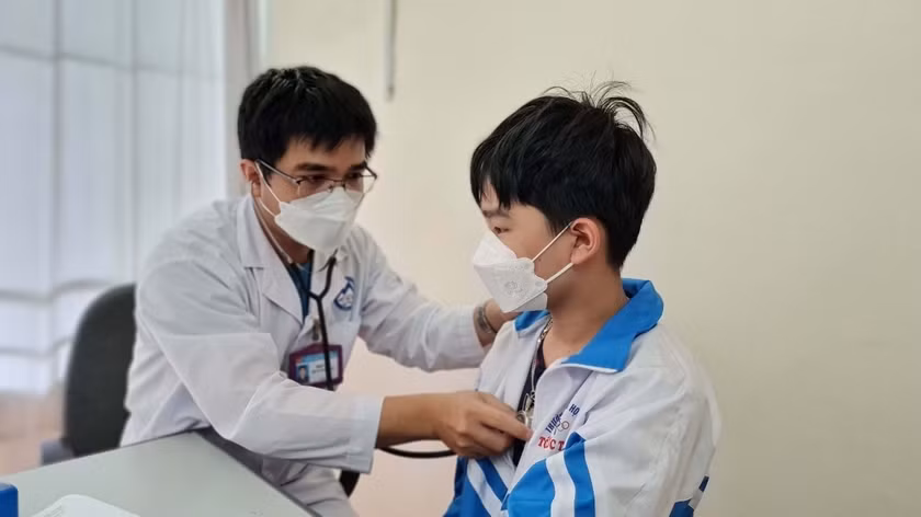 Nhân viên y tế kiểm tra sức khỏe cho trẻ trước khi tiêm vắc xin phòng Covid-19 tại Trung tâm Y tế TP. Pleiku. Ảnh: Bá Bính