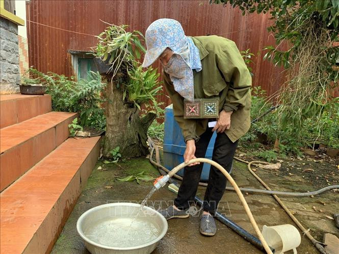 Bà Phan Thị Hướng sử dụng nước sạch do Công ty Trách nhiệm hữu hạn Một thành viên Nhôm Lâm Đồng-TKV cung cấp. Ảnh: TTXVN phát Bà Phan Thị Hướng sử dụng nước sạch do Công ty Trách nhiệm hữu hạn Một thành viên Nhôm Lâm Đồng-TKV cung cấp. Ảnh: TTXVN phát