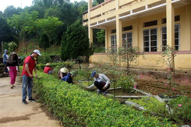Các thầy, cô giáo Trường tiểu học Quang Trung, huyện miền núi Ngọc Lặc, Thanh Hóa dọn dẹp vệ sinh, tỉa cây để chuẩn bị đón năm học mới. Ảnh: Nguyễn Nam/TTXVN