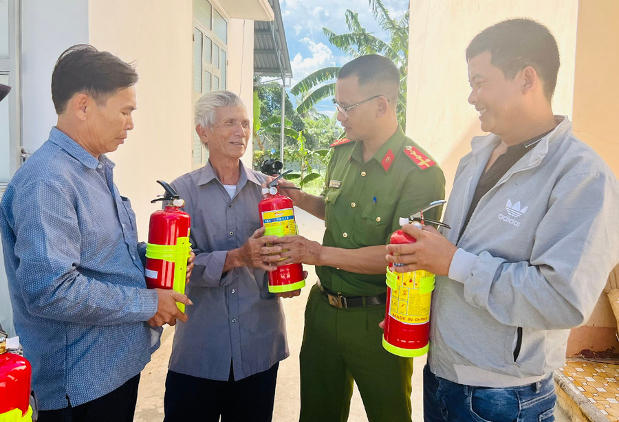 Cán bộ Công an xã Tú An hướng dẫn người dân sử dụng bình chữa cháy. Ảnh: N.H Cán bộ Công an xã Tú An hướng dẫn người dân sử dụng bình chữa cháy. Ảnh: N.H