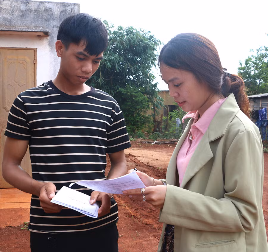 Anh Rmah Thoai (làng Thơ Ga B, xã Chư Don) được Phó Bí thư Đoàn xã Hà Thị Hồng Quyên hướng dẫn viết lý lịch xin vào Đảng. Ảnh: Q.T