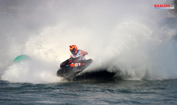 Mô tô số 27 đang vượt qua khúc cua với tốc độ rất cao, khiến mặt nước vung bọt trắng xóa Mô tô số 27 đang vượt qua khúc cua với tốc độ rất cao, khiến mặt nước vung bọt trắng xóa