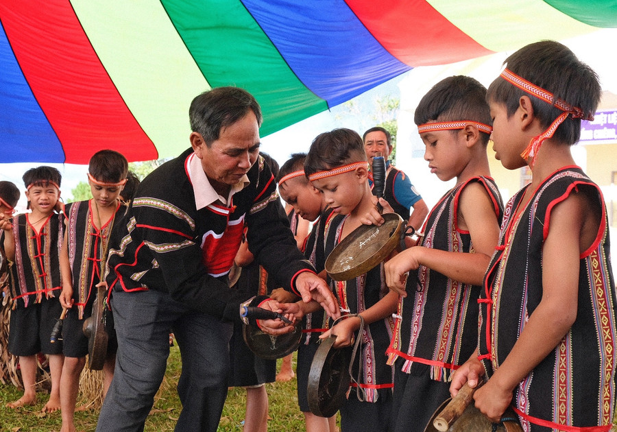 Nghệ nhân Ưu tú Alip truyền dạy cồng chiêng cho thế hệ trẻ. Ảnh: M.C