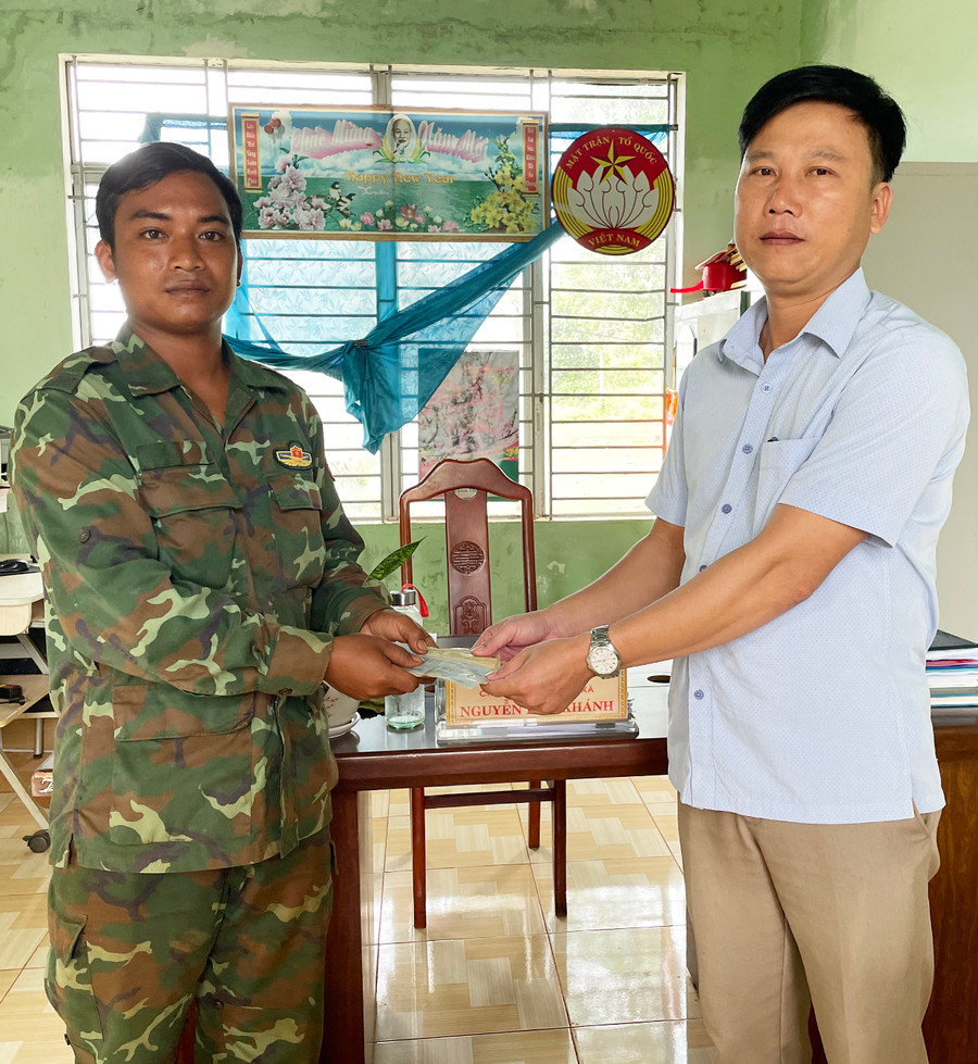 Anh Huynh trao toàn bộ số tiền của dân làng Vel quyên góp cho Ủy ban MTTQ Việt Nam xã Ia Ko. Ảnh: Văn Ngọc