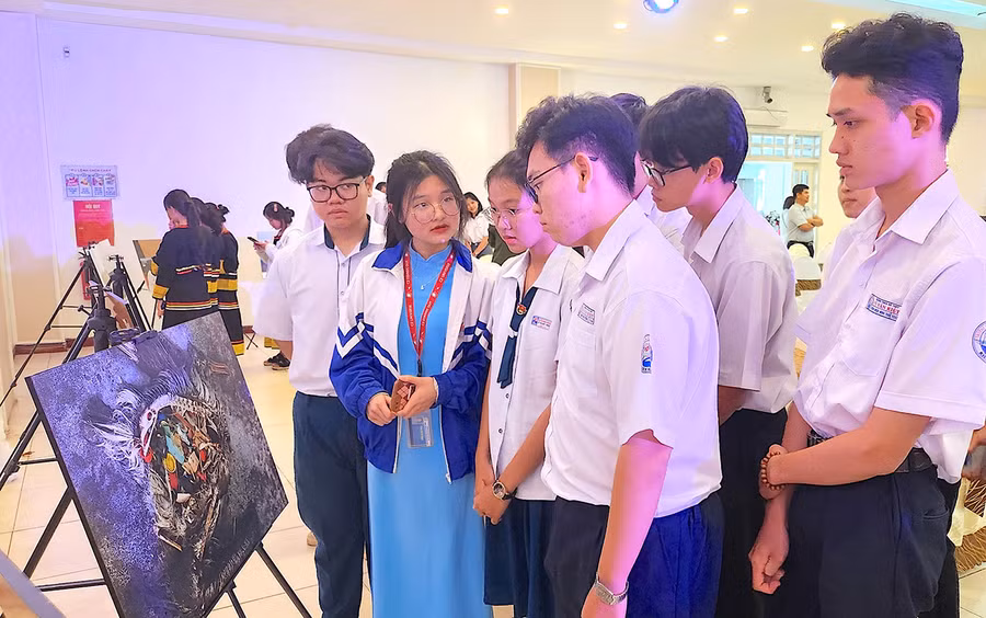 Em Đậu Minh Nga (thứ 2 từ trái sang, lớp 12C2A, Trường THPT chuyên Hùng Vương) cùng các thành viên trong nhóm thảo luận lựa chọn bức tranh để thuyết trình về chủ đề ô nhiễm môi trường. Ảnh: M.T