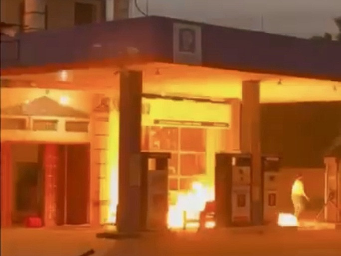 Người phụ nữ bất ngờ châm lửa đốt cây xăng cháy - Ảnh 1. Hình ảnh người phụ nữ châm lửa khiến cây xăng cháy.