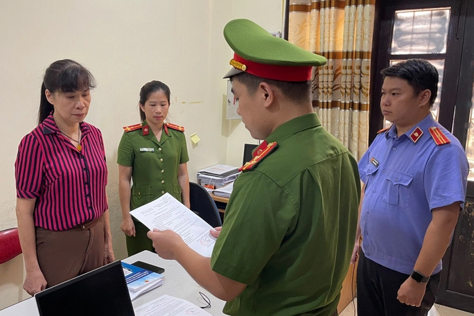 Một nữ chủ tịch UBND phường bị khởi tố, cấm đi khỏi nơi cư trú - Ảnh 1. Cơ quan chức năng tống đạt quyết định khởi tố bị can với Nông Thị Nghiệp.