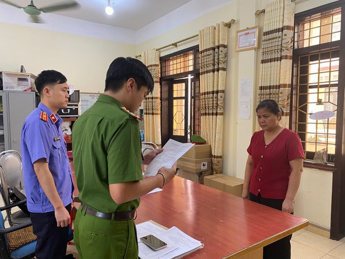 Một nữ chủ tịch UBND phường bị khởi tố, cấm đi khỏi nơi cư trú - Ảnh 3. Cơ quan điều tra tống đạt quyết định khởi tố bị can đối với Mã Thúy Huyền.
