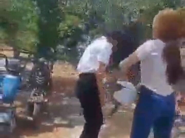 Nữ sinh bị nhóm bạn cầm mũ bảo hiểm đánh vào đầu. (Ảnh cắt từ clip)