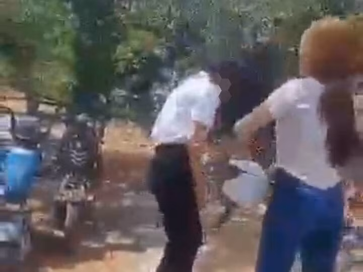 Nữ sinh bị nhóm bạn cầm mũ bảo hiểm đánh vào đầu. (Ảnh cắt từ clip)