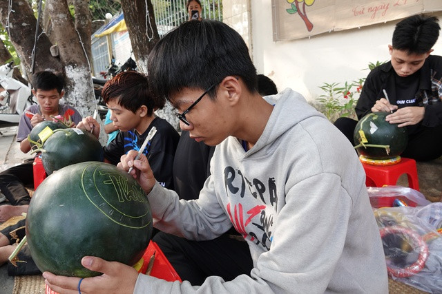 Học sinh khiếm thính thành thục việc điêu khắc chữ thư pháp trên dưa hấu. ẢNH DUY TÂN Học sinh khiếm thính thành thục việc điêu khắc chữ thư pháp trên dưa hấu. ẢNH DUY TÂN