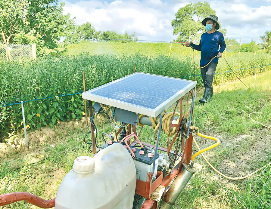 Ông Phạm Văn Bình sử dụng máy do mình sáng chế để phun thuốc bảo vệ thực vật cho hoa. Ảnh: L.N Ông Phạm Văn Bình sử dụng máy do mình sáng chế để phun thuốc bảo vệ thực vật cho hoa. Ảnh: L.N
