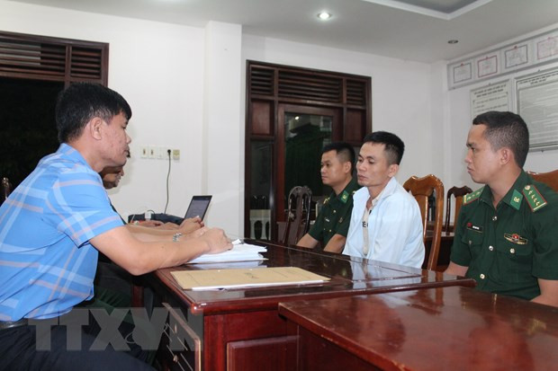 Đối tượng Nguyễn Văn Thương (giữa, bên phải) tại cơ quan chức năng. (Ảnh: TTXVN phát)