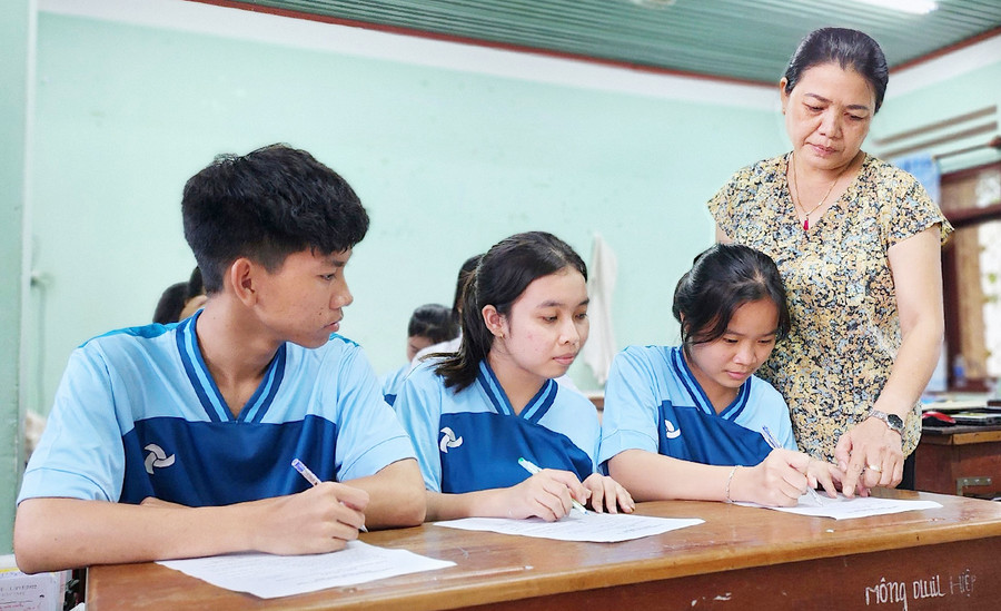 Nhân viên y tế Trường Phổ thông Dân tộc nội trú tỉnh hướng dẫn học sinh ký cam kết chấp hành tốt Luật Hôn nhân và Gia đình. Ảnh: M.T