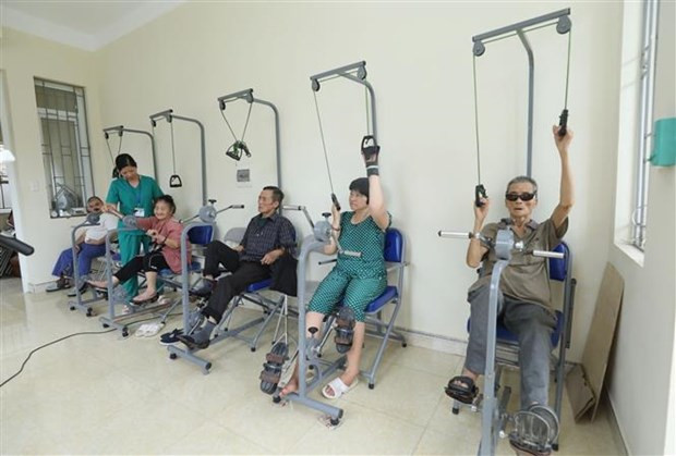 Cán bộ Cơ sở Bảo trợ Xã hội Tổng hợp tỉnh Lạng Sơn hướng dẫn các đối tượng tập phục hồi chức năng tại Cơ sở. (Ảnh: Anh Tuấn/TTXVN)