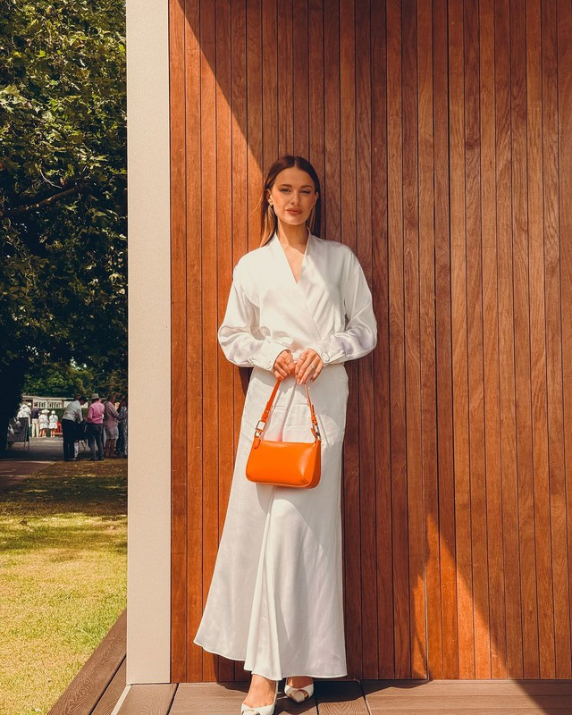 Chất liệu vải lụa tơ tằm, lụa satin tổng hợp được ưa thích đặc biệt trong mùa nắng nóng bởi hình ảnh dịu dàng nữ tính và khả năng tạo nên sự thoáng mát đặc biệt. Bạn có thể áp dụng theo công thức phối đồ của người mẫu Victoria - cô đi xem trận đấu tennis cùng chồng trong bộ đồ trắng tinh với chân váy lụa dài, áo lụa mềm cổ chữ V và chiếc túi xách màu cam tươi tắn, nổi bật. Ảnh Victoria Chất liệu vải lụa tơ tằm, lụa satin tổng hợp được ưa thích đặc biệt trong mùa nắng nóng bởi hình ảnh dịu dàng nữ tính và khả năng tạo nên sự thoáng mát đặc biệt. Bạn có thể áp dụng theo công thức phối đồ của người mẫu Victoria - cô đi xem trận đấu tennis cùng chồng trong bộ đồ trắng tinh với chân váy lụa dài, áo lụa mềm cổ chữ V và chiếc túi xách màu cam tươi tắn, nổi bật. Ảnh Victoria