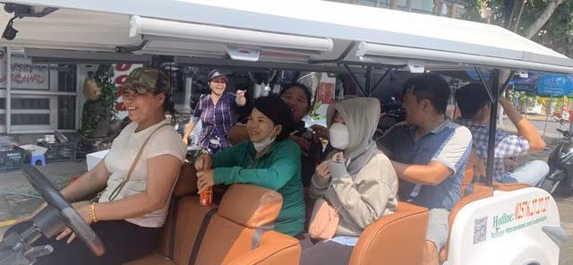 Du khách thích thú khi trải nghiệm quanh TP.Tuy Hòa bằng xe điện. Ảnh: TRẦN NGÂN