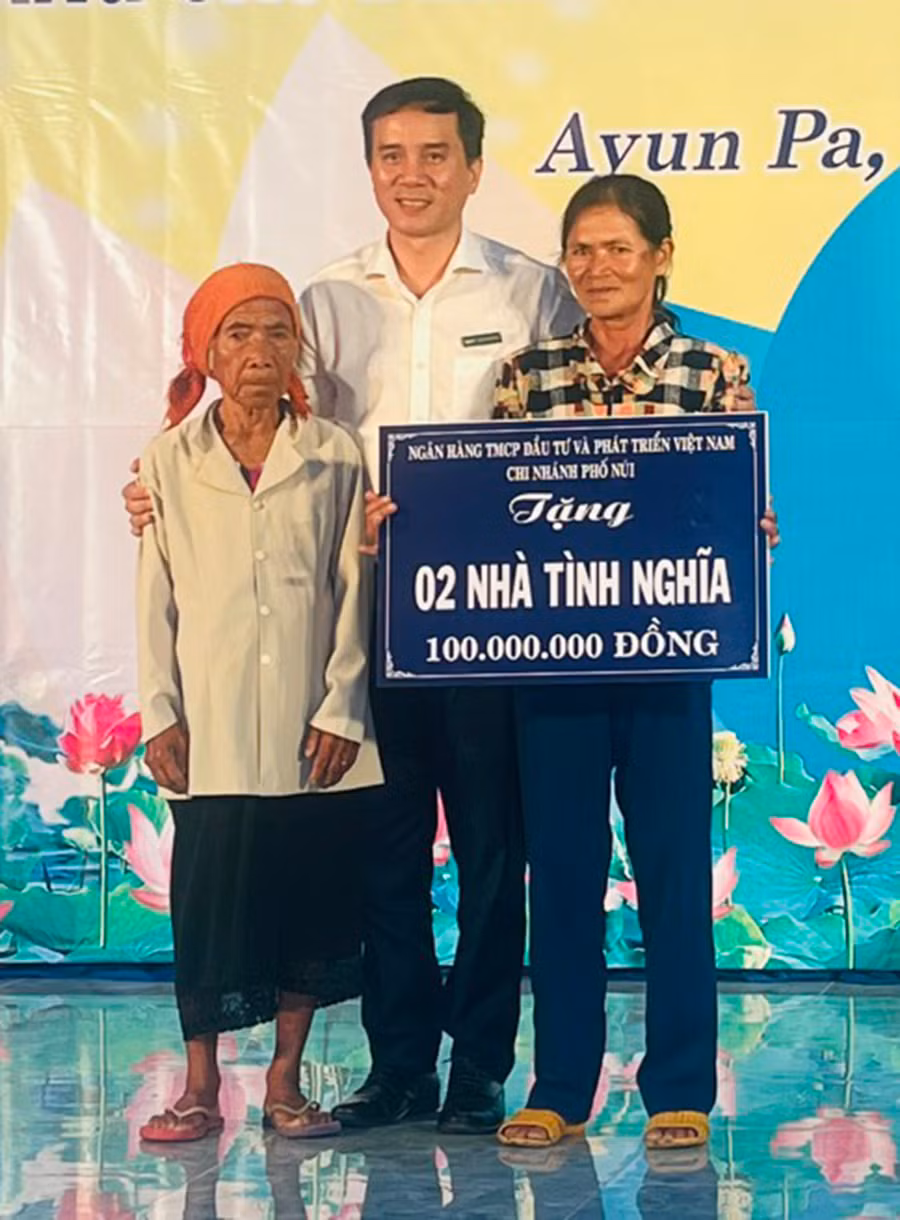 Lãnh đạo BIDV Phố Núi hỗ trợ kinh phí xây nhà tình nghĩa cho hộ bà Nay H'Đim (bìa trái) và chị Nay H'Blot (cùng ở buôn Rưng Ma Nhiu). Ảnh: V.C