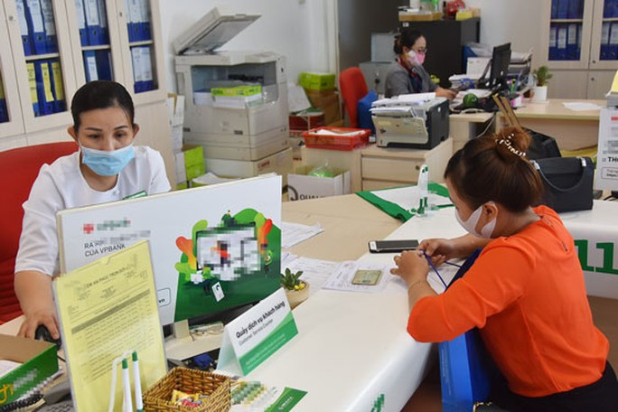 Ngóng quy định vay vốn mới từ 1-9 - Ảnh 1. Nhiều khách hàng đang tìm hiểu về các chương trình cho vay ưu đãi và thủ tục để chuyển khoản vay sang NH khác sau ngày 1-9 . Ảnh: TẤN THẠNH