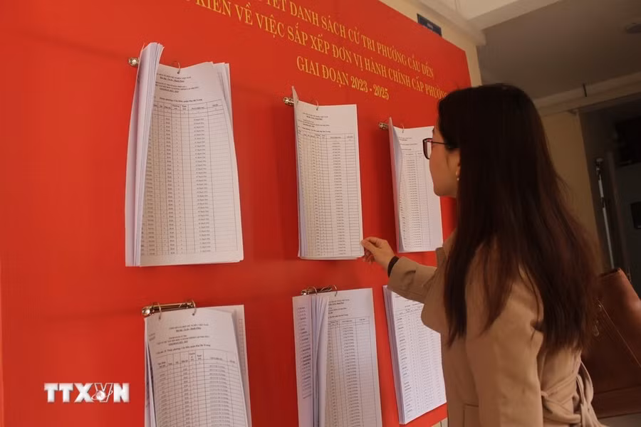 Người dân xem thông báo niêm yết danh sách cử tri, lấy ý kiến việc sắp xếp đơn vị hành chính cấp phường, trên địa bàn phường Cầu Dền, Hà Nội. (Ảnh: Nguyễn Thắng/TTXVN) Người dân xem thông báo niêm yết danh sách cử tri, lấy ý kiến việc sắp xếp đơn vị hành chính cấp phường, trên địa bàn phường Cầu Dền, Hà Nội. (Ảnh: Nguyễn Thắng/TTXVN)