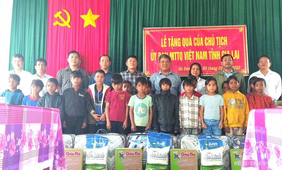 Chủ tịch Ủy ban MTTQ Việt Nam tỉnh Hồ Văn Điềm (hàng sau, thứ 4 từ phải qua) tặng quà cho Trường Phổ thông dân tộc bán trú Tiểu học Hà Đông. Ảnh: Lê Đại